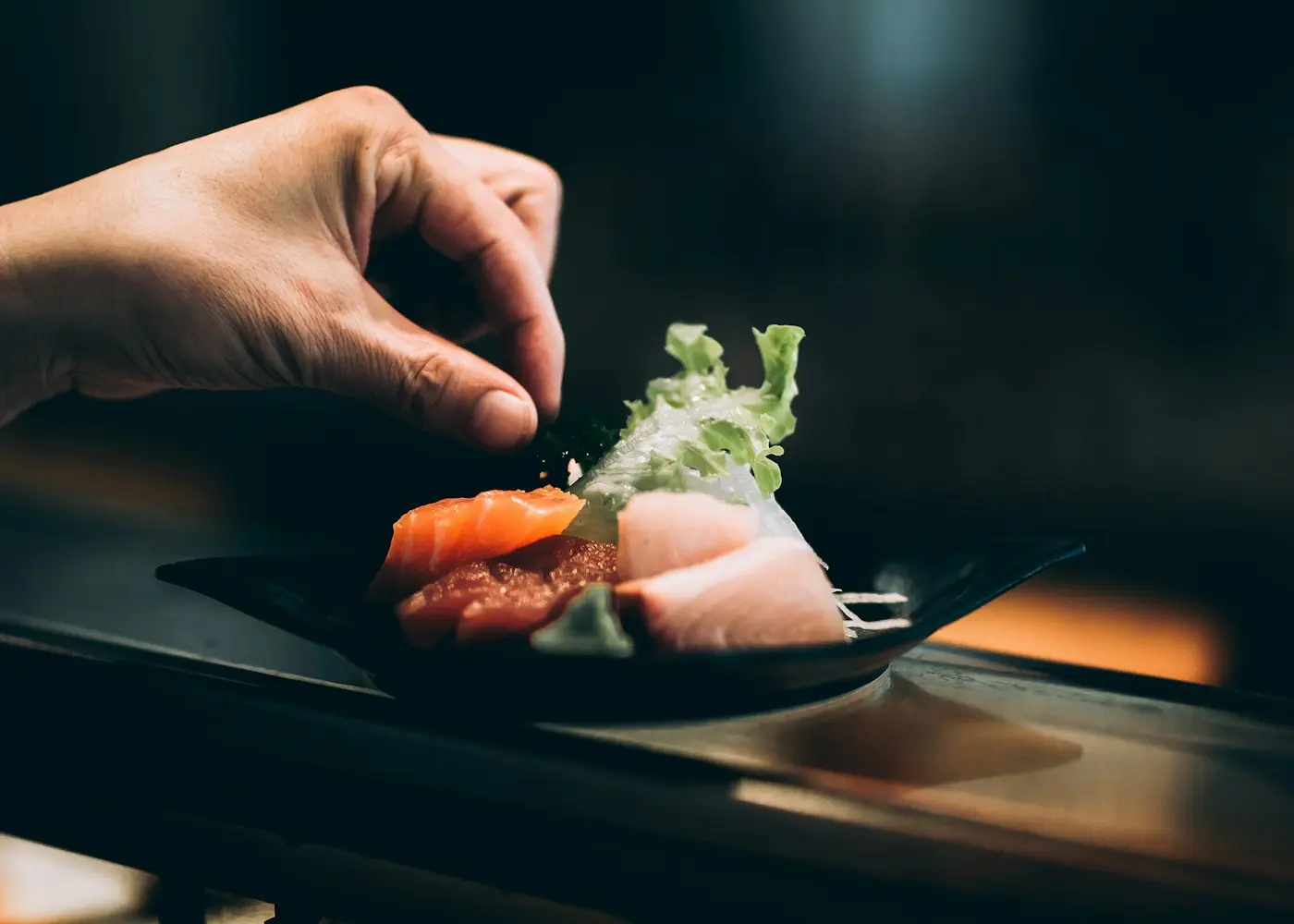 Sushiman de Club de Sushi preparando un roll con salmón fresco